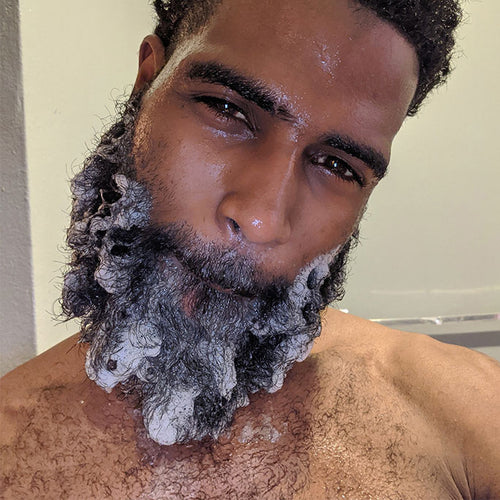 Black man with his beard full of bubbling soap